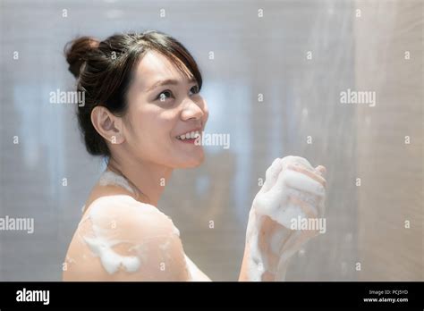 Young Asian Woman Taking A Shower In The Bathroom With Shower Head Looking Happy And Relax