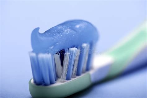 Close Up Of A Toothbrush With Smeared Blue Toothpaste On A Blue