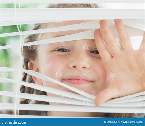 Smiling Girl Looking Through The Blinds Stock Photo Image Of Happy