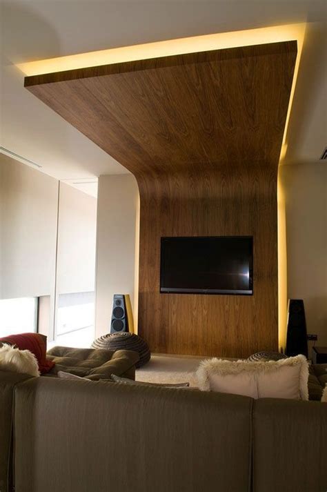 A Living Room With A Flat Screen Tv Mounted On The Wall And Wooden Paneling