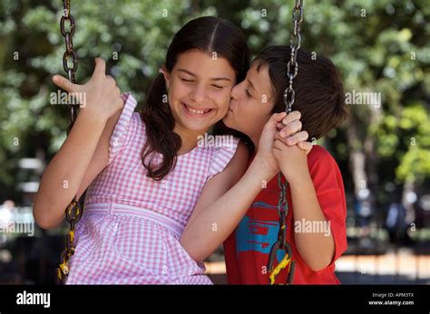 Little Boy Kissing Sister In Playground Stock Photo Alamy
