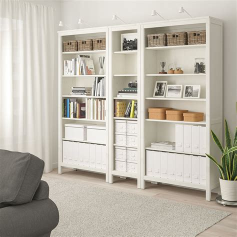 A Living Room Filled With Furniture And A White Book Shelf Next To A