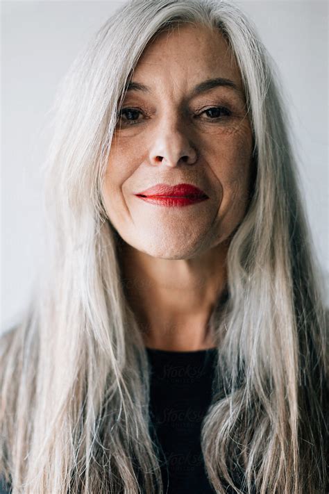 Portrait Of An Attractive Senior Woman With Grey Long Hair Looking At Camera By Stocksy