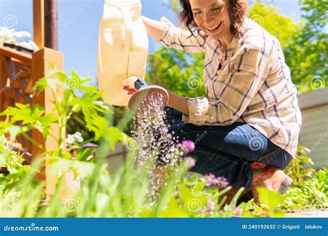 A Woman Is Gardening In Her Backyard She Plants Seedlings Stock Photo