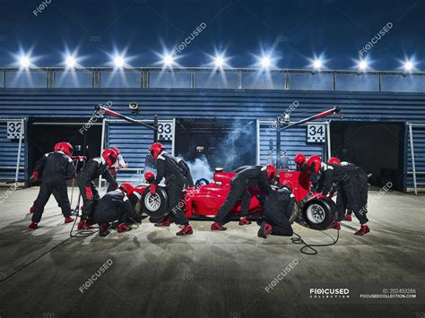 Pit Crew Working On Formula One Race Car In Pit Stop — Outside Sport