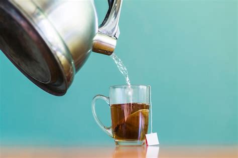 Free Photo Water Pouring Into Glass Cup Of Tea