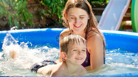 快乐的妈在家庭后院花园的游泳池里教她儿子游泳家庭暑假和期高清图片下载 正版图片306615186 摄图网