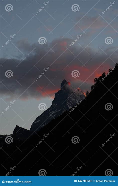 Summit Of Matterhorn Mountain Covered By Clouds Coloured Red Stock