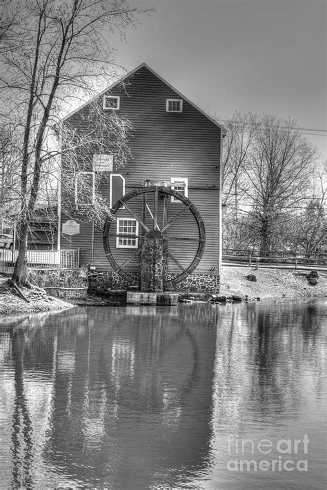 Reflections In Monochrome Of The Grist Mill Waterwheel In Historic