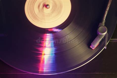 Record Player With A Spinning Black Vinyl Record Reflecting Color