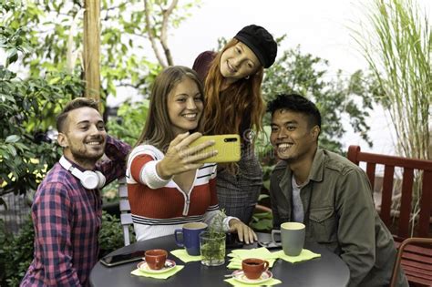 Multicultural Happy Friends Having Fun Taking Group Selfie Portrait Outside In The Garden During