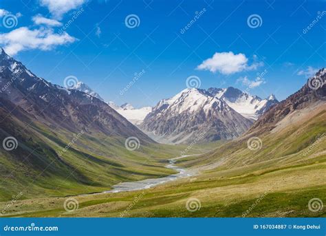 Majestic Snow Capped Mountain Peak With Green Alpine Meadows Stock