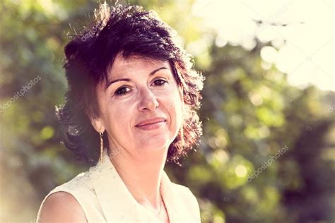Woman In Her 50s Smiling Outdoors Portrait Stock Photo By ©nadinasa