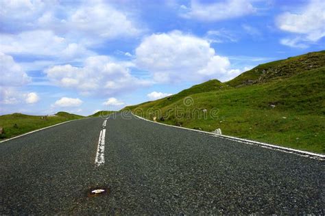 The Road Ahead Steep Uphill Road With Grass Verges On Either Side With