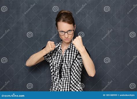 Portrait Of Focused Young Woman Holding Fists Clenched In Front Of Her