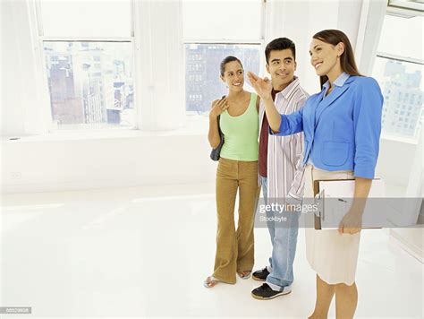 Female Real Estate Agent Showing A House To A Young Couple Photo