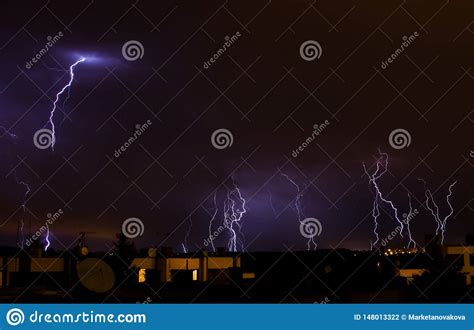 Lightning On The Sky During Summer Storm Above Houses Stock Photo