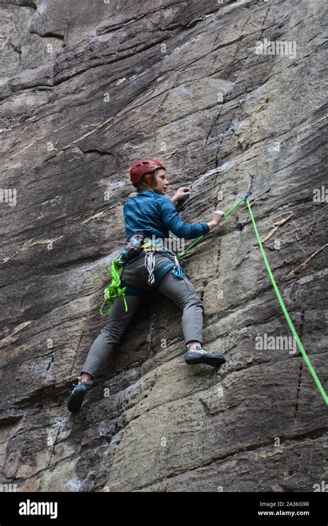 A Female Climber Works Her Way Up The Amphitheater Cliff Face On The