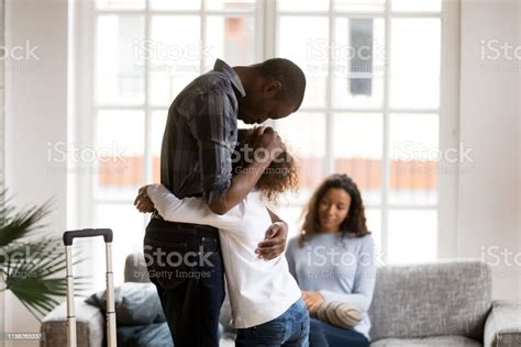 Sad African American Girl Hug Dad Leaving Home With Suitcase Stock