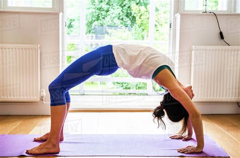 Woman Bending Over Backwards In Yoga Position Stock Photo Dissolve