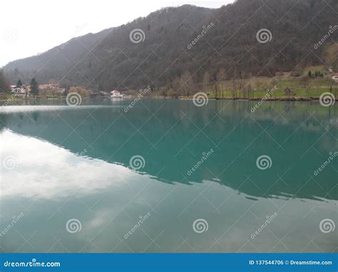 Mountain Lake With Turquoise Blue Water Surrounded By Alps And Green