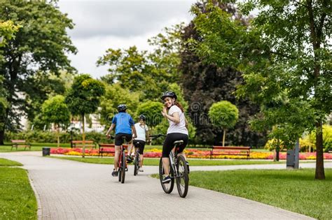 zdrowy styl życia szczęśliwi jeźdźcy na rowerach w parku miejskim zdjęcie stock obraz