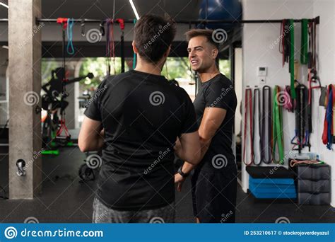 Two Personal Trainers Talking To Each Other At The Gym Stock Image