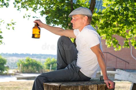 Man Sitting Outdoors Enjoying A Drink Stock Photo Image Of Bottle
