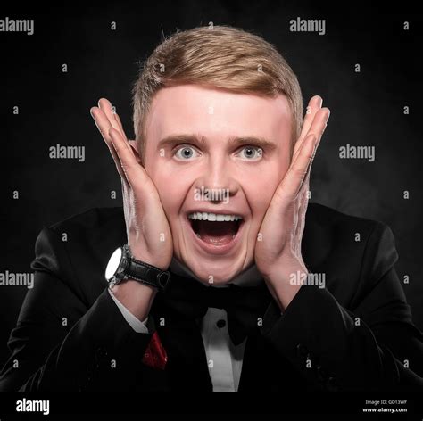 Portrait Of Surprised Man In Suit With Bow Tie Over Dark Background