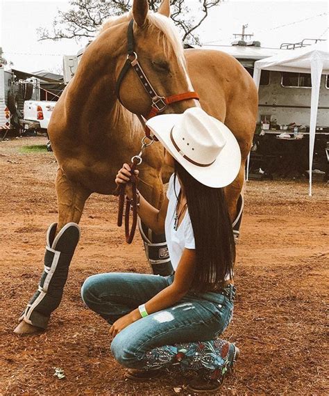 A Woman Kneeling Down Next To A Brown Horse