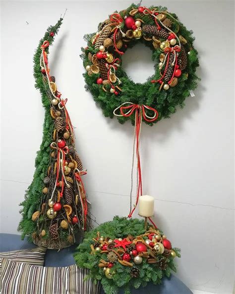 Two Christmas Wreaths Are Hanging On The Wall Next To A Table With A Candle