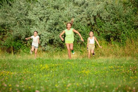 Kids Children Running On Meadow In Summer S Sunlight Stock Photo