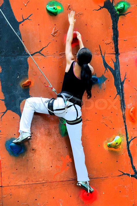 girl climbing on a climbing wall training in insurance stock image colourbox