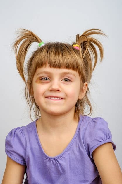 retrato de niña sonriente con coletas y hematoma debajo del ojo foto premium