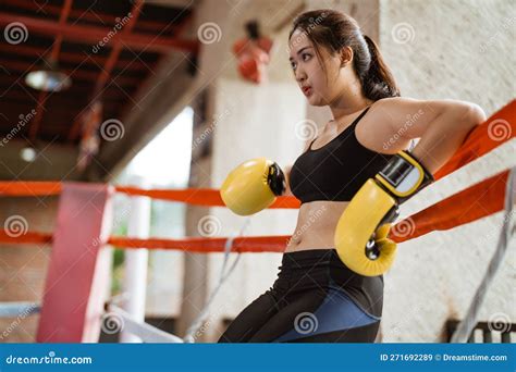 A Beautiful Boxer With Yellow Boxing Gloves Leaning On The Ropes Stock