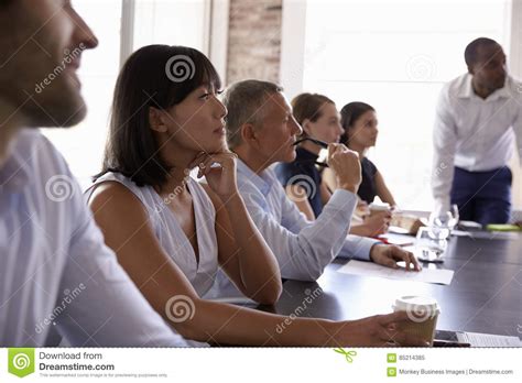 Businesspeople Listening To Presentation In Boardroom Stock Image
