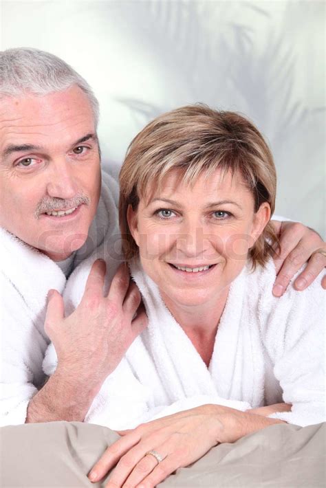 Mature Couple In Bathrobe Laid On A Bed Stock Image Colourbox
