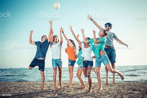 Gruppo Di Amici A Giocare Con Palla In Spiaggia Fotografie Stock E