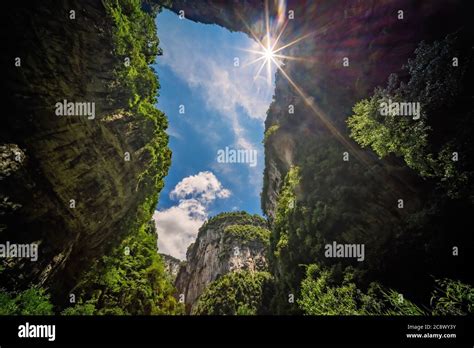 Sun Shining Through The Natural Rocky Arch And Karst Landscape Of The