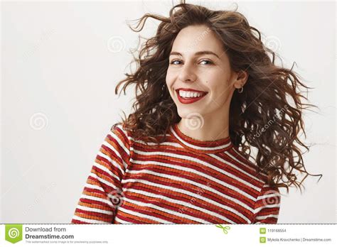 waist up shot of carefree fashionable woman with curly hair and red lipstick smiling broadly