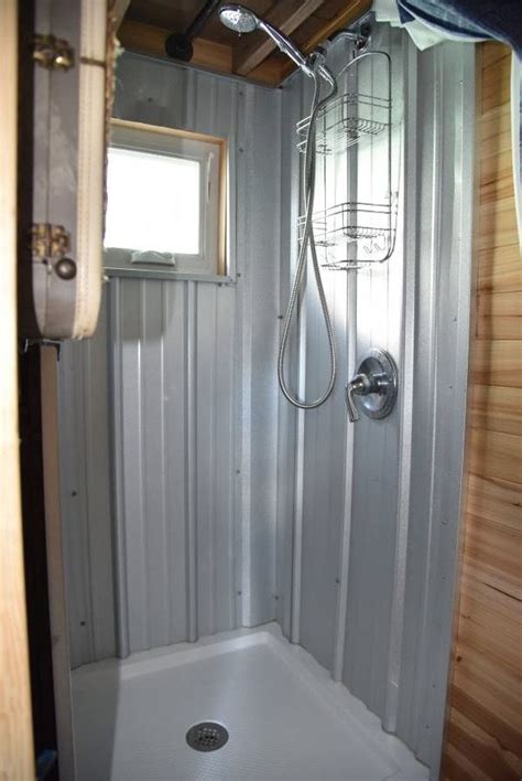 There Is A Shower In The Corner Of This Bathroom With Wood Paneling On