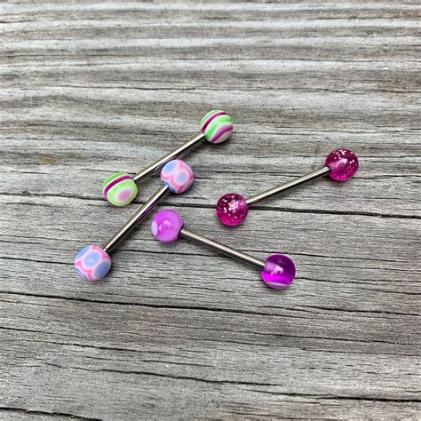Three Purple Green And Pink Candy Lollipops Sitting On Top Of A Wooden