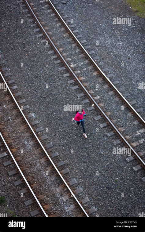 Woman Running Across Railroad Tracks Stock Photo Alamy