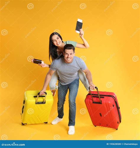Couple With Suitcases And Passports For Summer Trip On Yellow