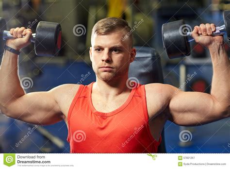 Young Man With Dumbbells Flexing Muscles In Gym Stock Image Image Of