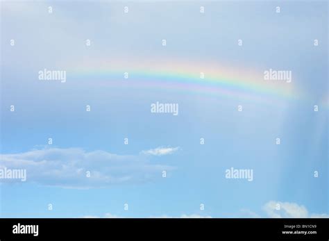 Rainbow In Blue Sky With Few Clouds Stock Photo Alamy