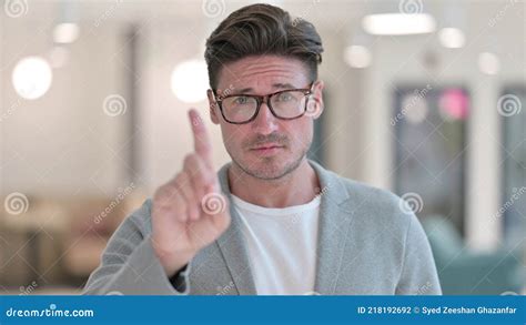 Portrait Of Middle Aged Man Saying No With Finger Gesture Stock Photo