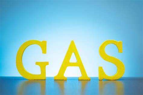 Premium Photo Yellow Wooden Letters Forming The Word Gas On Blue