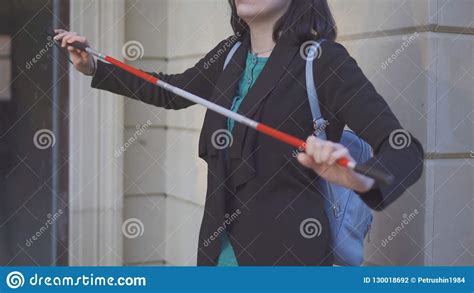 Cane For The Blind In The Hands Of A Young Stylish Woman On The Street