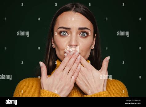 Shocked Beautiful Girl Expressing Surprise And Covering Her Mouth Isolated Over Green Background